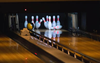 bowling ball knocking down pins